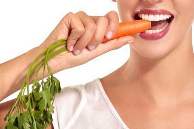 The girl eats raw carrot